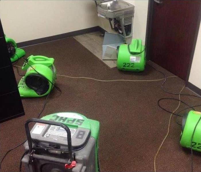 servpro green drying equipment on a wet carpet