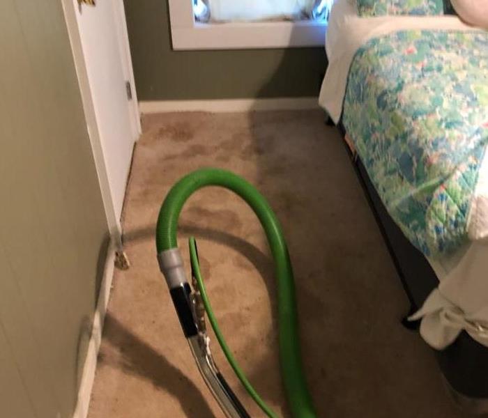 Carpet cleaning hose in bedroom