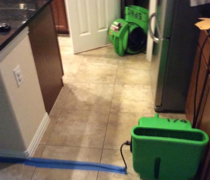 Water damage equipment on a tiled, kitchen floor
